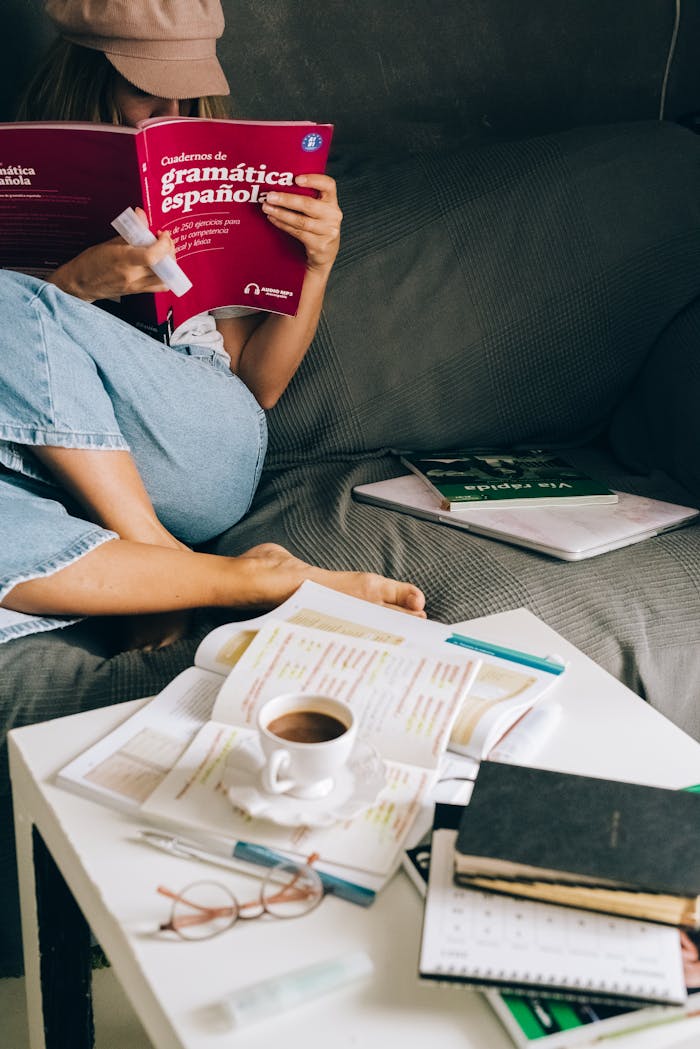 classes-01 Woman studying Spanish grammar at home with coffee, books, and notes.